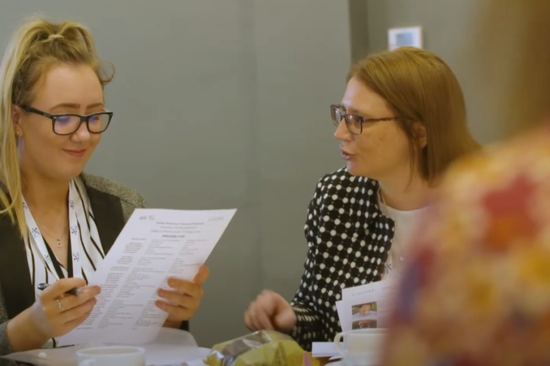 Two professionals discussing knowledge exchange